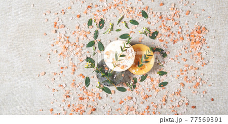 The round handmade soaps and salt with the eucalyptus on the cotton background. The round handmade soaps and salt with the eucalyptus on the cotton background. 77569391