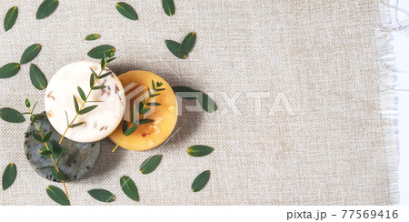 The natural handmade soaps with the twigs of eucalyptus on the cotton background The natural handmade soaps with the twigs of eucalyptus on the cotton background 77569416