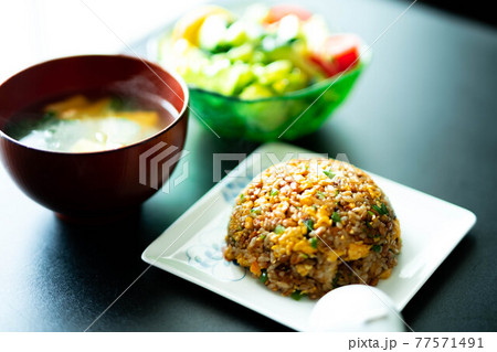 納豆チャーハンと野菜サラダでバランスの良いランチをとる 77571491