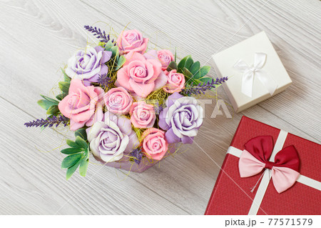 Gift boxes with flowers on the gray background Gift boxes with flowers on the gray background 77571579