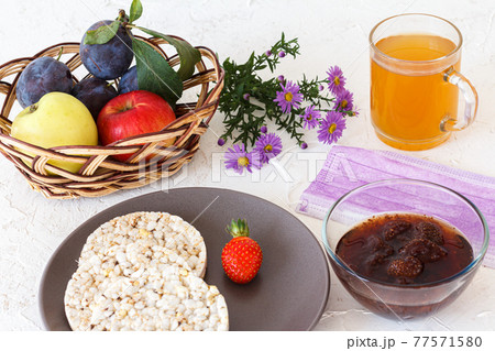 Puffed rice cakes and strawberry on the plate with fruits and a cup of tea Puffed rice cakes and strawberry on the plate with fruits and a cup of tea 77571580