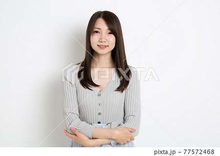 両手を前に組み笑っている若い女性 両手を前に組み笑っている若い女性 77572468