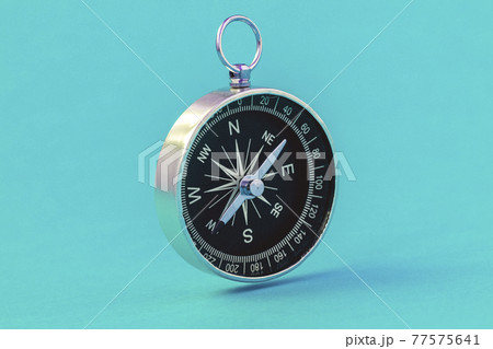 Black compass floating on the blue background Black compass floating on the blue background 77575641