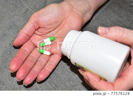 Pills in capsules in woomen hand. Medicine grade pharmaceutical tablets. Medical pill Pills in capsules in woomen hand. Medicine grade pharmaceutical tablets. Medical pill 77576128