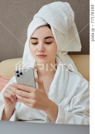 young beautiful caucasian woman in white bathrobes and towels on heads 77576388