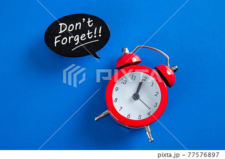 Hand writting a word Don't Forget notice reminder words on blue background Hand writting a word Don't Forget notice reminder words on blue background 77576897