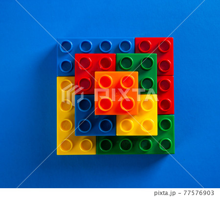 Color plastic building blocks on blue background Color plastic building blocks on blue background 77576903