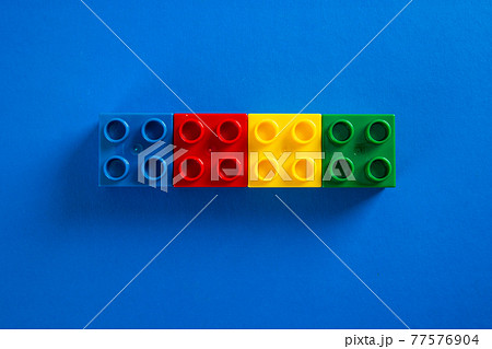 Color plastic building blocks on blue background Color plastic building blocks on blue background 77576904