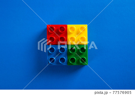 Color plastic building blocks on blue background Color plastic building blocks on blue background 77576905