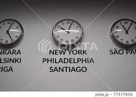 Many wall clocks on the white wall of business office showing time of different cities of the world Many wall clocks on the white wall of business office showing time of different cities of the world 77577658