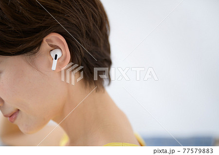 ミドル女性　イヤホン　くつろぐ　耳 77579883