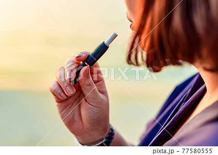 加熱式たばこを吸う女性の写真素材