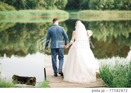 Romantic wedding moment, couple of newlyweds smiling portrait, bride and groom hugging Romantic wedding moment, couple of newlyweds smiling portrait, bride and groom hugging 77582872