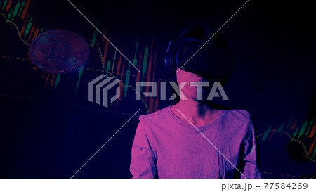Businesswoman with VR headset in Virtual stock market. Finger touching a virtual display with graph. Stock statistics. represent investment in virtual cryptocurrency stock market. stock market data. Businesswoman with VR headset in Virtual stock market. Finger touching a virtual display with graph. Stock statistics. represent investment in virtual cryptocurrency stock market. stock market data. 77584269