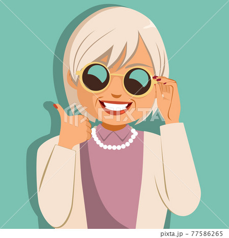 Funny cheerful old woman holding sunglasses making thumbs up hand gesture 77586265