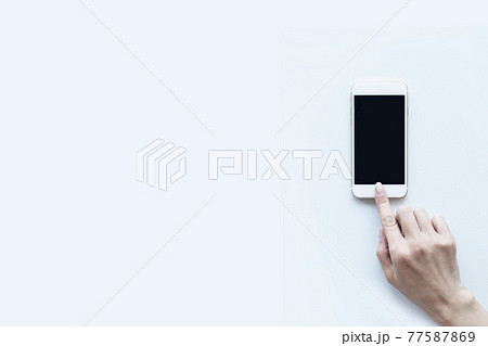 スマートフォンを操作する女性の手 白バック スマートフォンを操作する女性の手 白バック 77587869