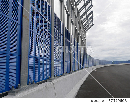 SELANGOR, MALAYSIA - JULY 5, 2020: Noise barriers are installed along the vehicle lane bordering the residence to prevent noise pollution to the surrounding locals. 77590608