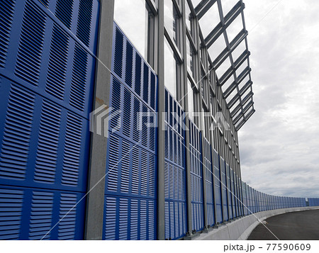 SELANGOR, MALAYSIA - JULY 5, 2020: Noise barriers are installed along the vehicle lane bordering the residence to prevent noise pollution to the surrounding locals. SELANGOR, MALAYSIA - JULY 5, 2020: Noise barriers are installed along the vehicle lane bordering the residence to prevent noise pollution to the surrounding locals. 77590609