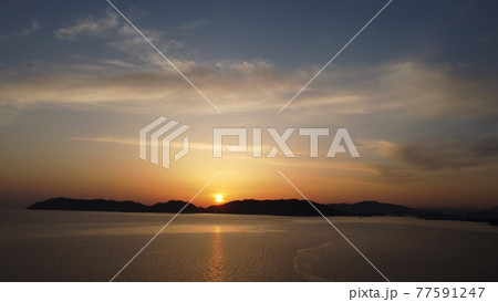 瀬戸内海に沈む太陽の光と七色のソラ ドローン空撮山口県光市虹ヶ浜海水浴場 マジックアワーの美しい景色の写真素材