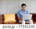 asian senior man using computer laptop at home 77591295