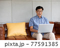 asian senior man using computer laptop at home 77591385
