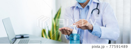 Medical concept a male doctor wearing mask and using hand sanitizer alcohol gel for preventing against infection of Coronavirus (Covid-19) outbreak at his modern clinic Medical concept a male doctor wearing mask and using hand sanitizer alcohol gel for preventing against infection of Coronavirus (Covid-19) outbreak at his modern clinic 77591489