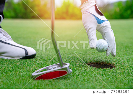 Close up golf ball on green grass field 77592194