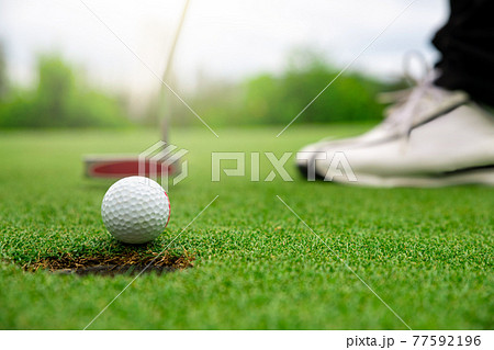 Close up golf ball on green grass field 77592196