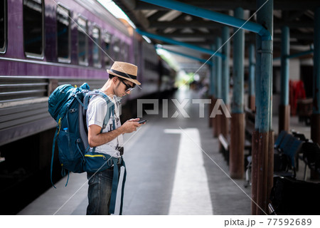 Traveler waits train at train station Traveler waits train at train station 77592689