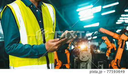 Engineer use advanced robotic software to control industry robot arm in factory 77593649