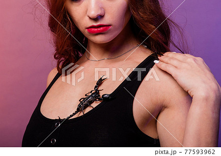 Beautiful seductive fashion redhead female with make up with a scorpion in studio 77593962