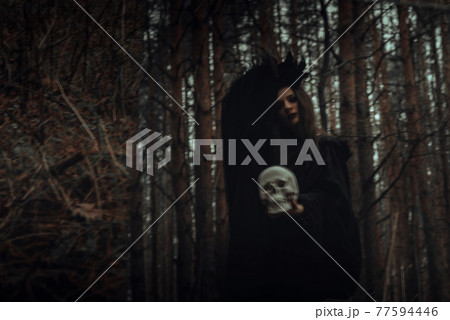 blurred mystical silhouette of an evil scary witch with a dead man's skull in a mirror blurred mystical silhouette of an evil scary witch with a dead man's skull in a mirror 77594446