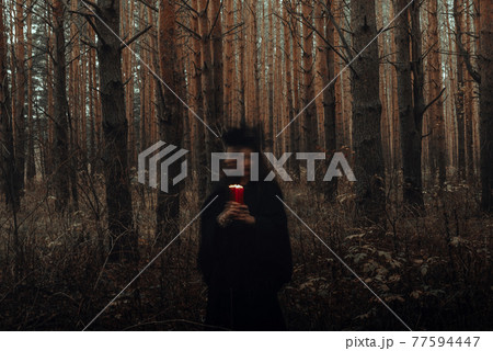dark terrible witch with candles in her hands performs an occult mystical ritual in the forest dark terrible witch with candles in her hands performs an occult mystical ritual in the forest 77594447