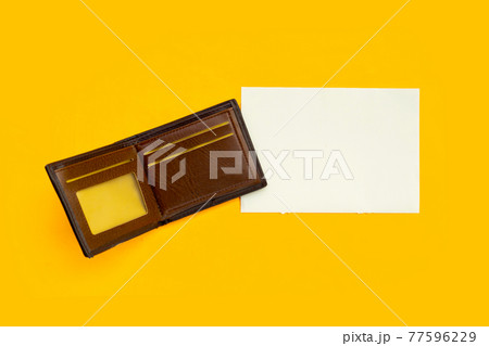Brown wallet with white paper on yellow background. Brown wallet with white paper on yellow background. 77596229