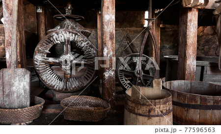 An ancient hand mill made of stones and wood. Flour grinding device An ancient hand mill made of stones and wood. Flour grinding device 77596563