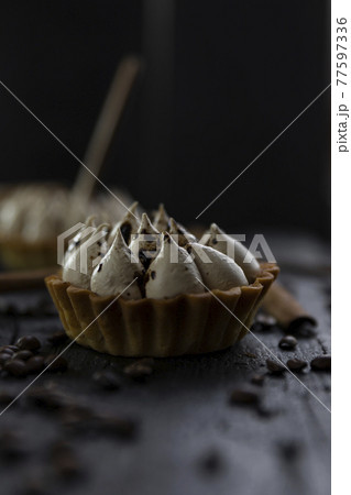 Cappuccino tart with cinnamon sticks and coffee beans on rustic wooden table 77597336