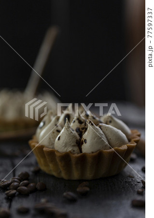 Cappuccino tart with cinnamon sticks and coffee beans on rustic wooden table 77597337