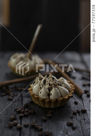 Cappuccino tart with cinnamon sticks and coffee beans on rustic wooden table 77597338