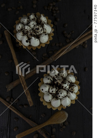 Cappuccino tart with cinnamon sticks and coffee beans on rustic wooden table Cappuccino tart with cinnamon sticks and coffee beans on rustic wooden table 77597340
