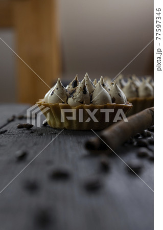 Cappuccino tart with cinnamon sticks and coffee beans on rustic wooden table Cappuccino tart with cinnamon sticks and coffee beans on rustic wooden table 77597346
