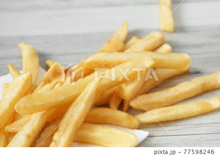 テーブルの上に散らばったフライドポテトのクローズアップ テーブルの上に散らばったフライドポテトのクローズアップ 77598246