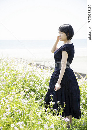 海を眺める若い女性と花畑（神奈川県鎌倉市由比ガ浜） 77598380