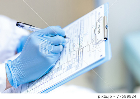 コロナウイルスワクチン予防接種の問診をする医師 77599924