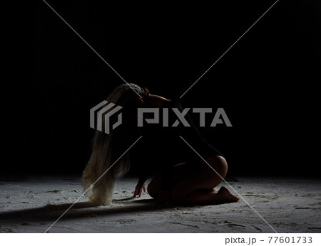 beautiful young woman of Caucasian appearance sits with her head down, long hair in flour beautiful young woman of Caucasian appearance sits with her head down, long hair in flour 77601733