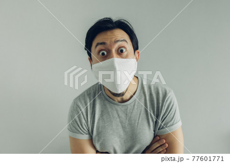 Wow face of man wearing hygienic mask and grey t-shirt. Wow face of man wearing hygienic mask and grey t-shirt. 77601771