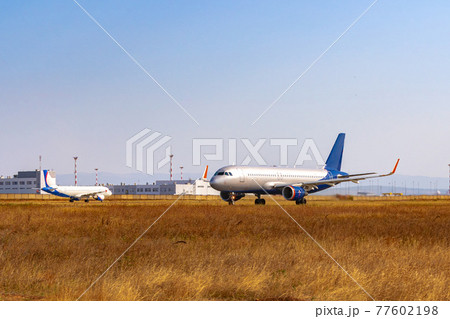 Big passenger airplane drives along the runway in airport 77602198