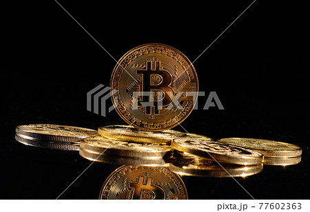 Closeup golden coin with bitcoin logo. Leader in cryptocurrency Bitcoin BTC on a top of coins against black mirror surface. A heap of decentralized digital currency. Crypto payment. Electronic money. 77602363