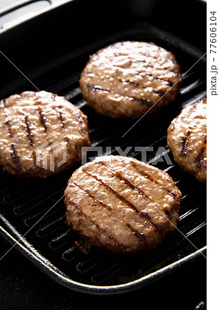 Cooked minced beef patty on grill pan. Cooking homemade burgers. Cooked minced beef patty on grill pan. Cooking homemade burgers. 77606104