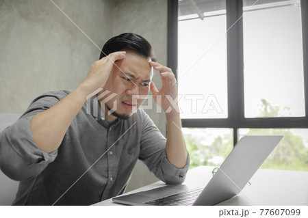 Serious face of man working on laptop alone in the room. Serious face of man working on laptop alone in the room. 77607099
