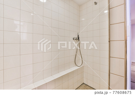 Shower tap in tiled bathroom 77608675